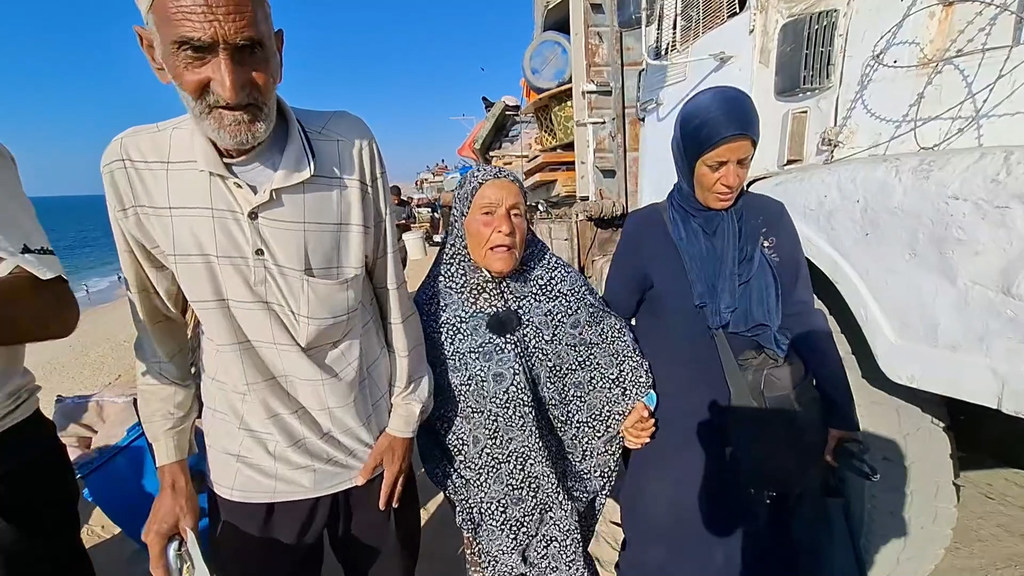 Desplazamiento en Gaza: Abu Nader Siam (izquierda), caminando con su esposa Zakia Siam (centro).